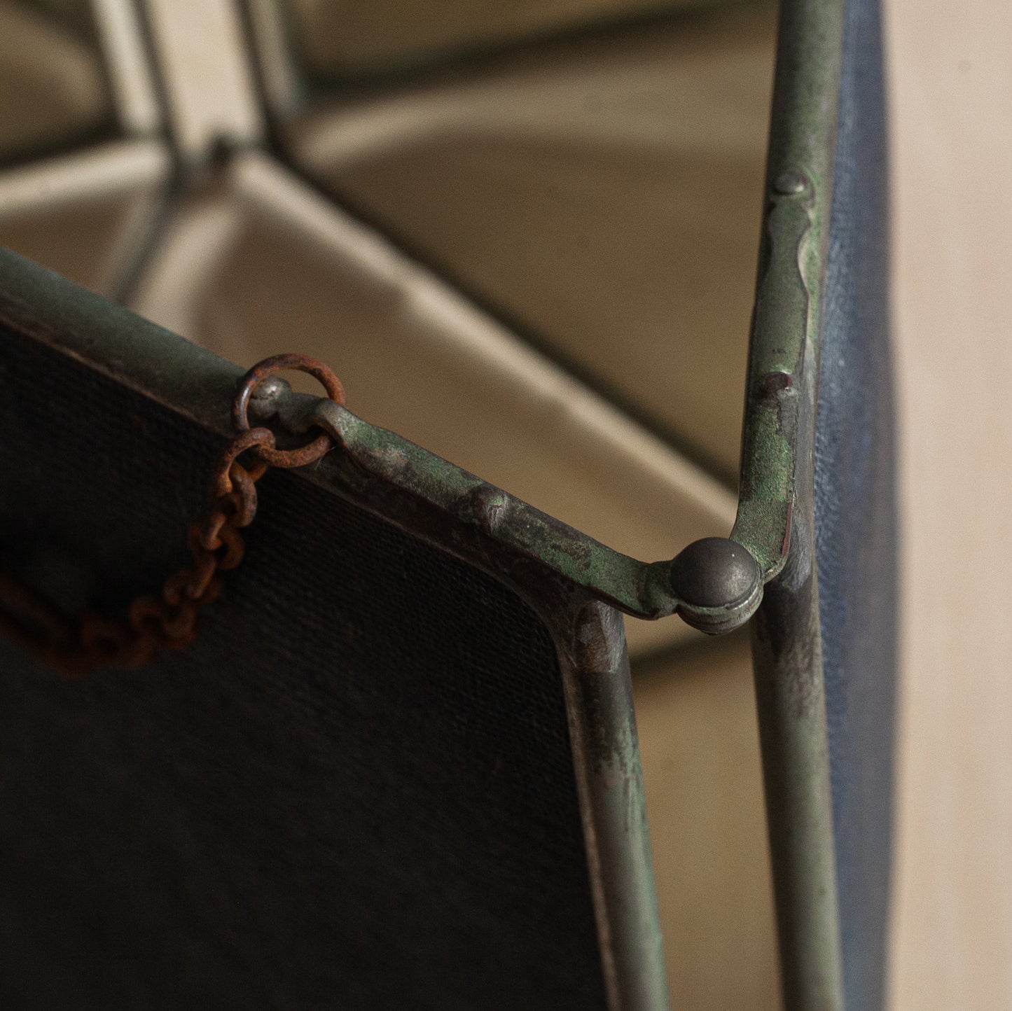 Close-up of a metal frame with a chain, showing signs of rust and wear.