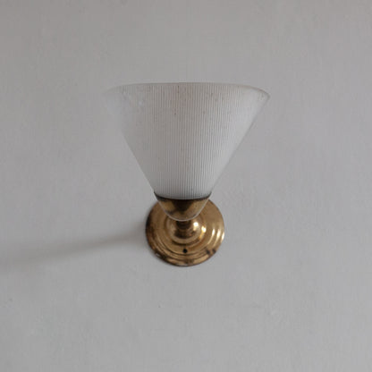 Small white lampshade with gold base on a plain background